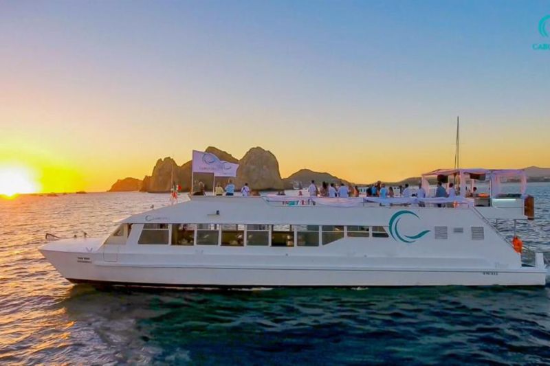 Large event catamaran at sunset with the silhouette of Land's End behind