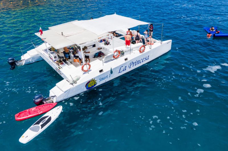 52-foot luxury power catamaran at anchor with a kayak and paddleboard alongside